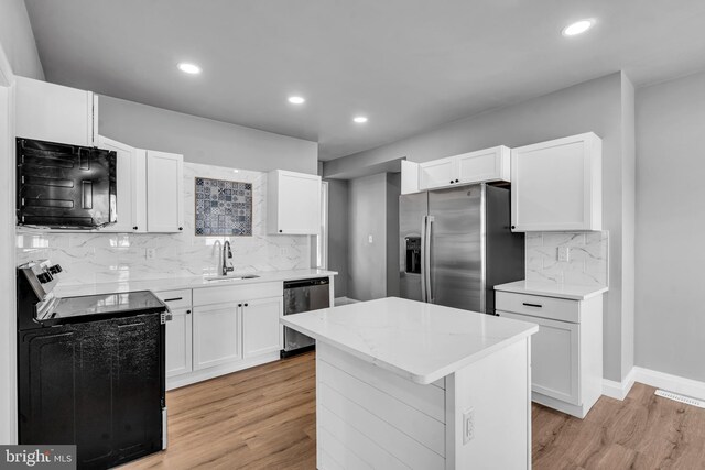 19 E Main St, Salem, NJ 08079 - kitchen featuring stainless steel appliances, a sink, tasteful backsplash, light wood-type flooring, and white cabinetry