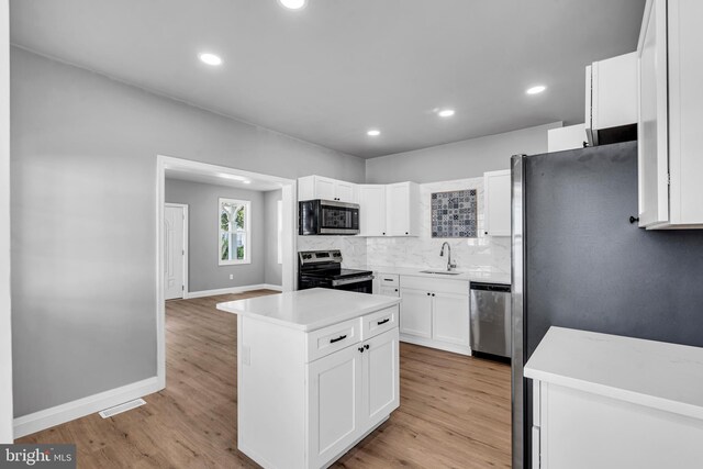 19 E Main St, Salem, NJ 08079 - kitchen featuring stainless steel appliances, a sink, white cabinets, light wood finished floors, and baseboards