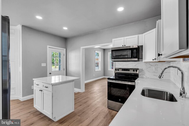 19 E Main St, Salem, NJ 08079 - kitchen with appliances with stainless steel finishes, a sink, baseboards, white cabinets, and tasteful backsplash