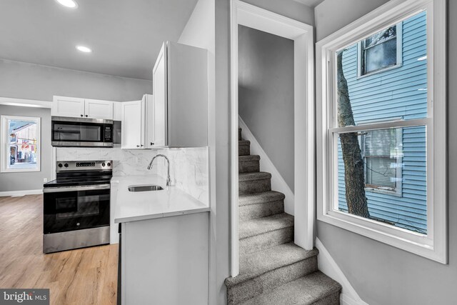19 E Main St, Salem, NJ 08079 - kitchen featuring stainless steel appliances, a sink, white cabinetry, baseboards, and light wood finished floors