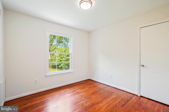 spare room featuring wood finished floors and baseboards