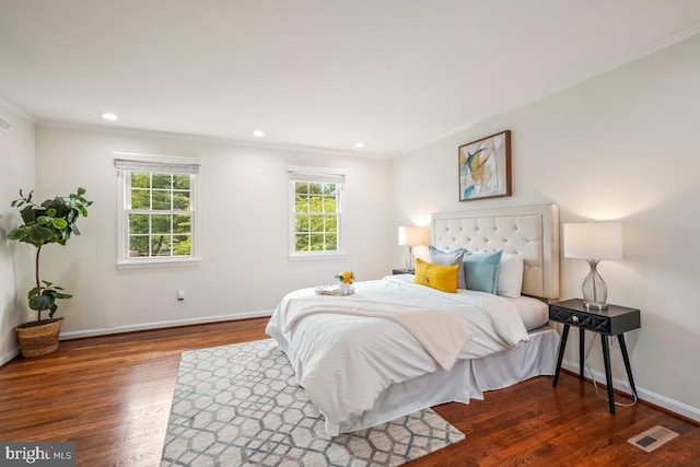bedroom with crown molding, wood finished floors, baseboards, and recessed lighting