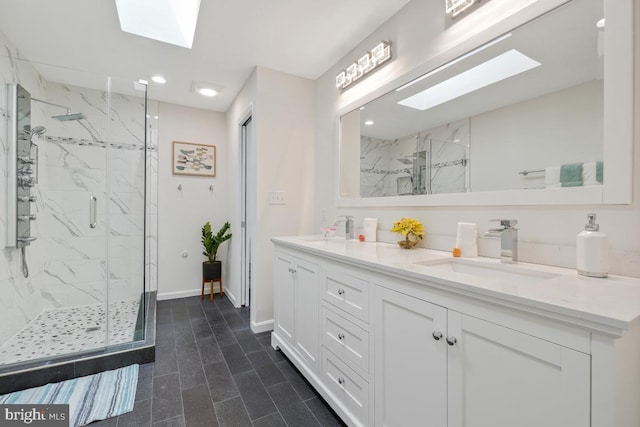 bathroom with a skylight, a marble finish shower, double vanity, and recessed lighting