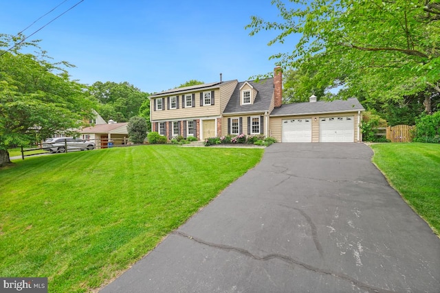 view of front facade with driveway, an attached garage, a chimney, and solar panels