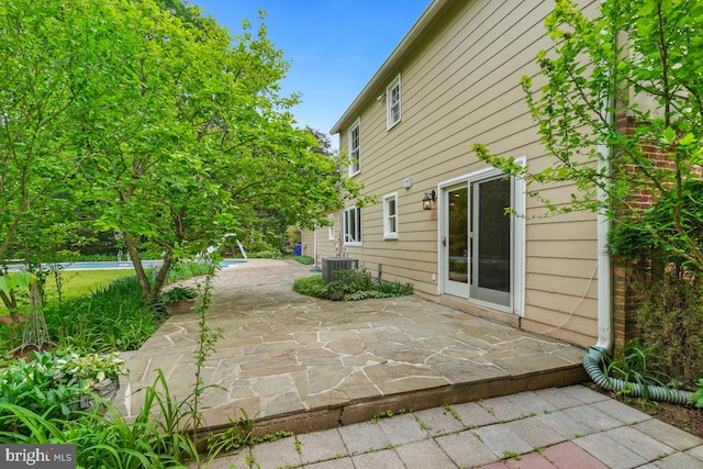 view of side of home with a patio and central AC