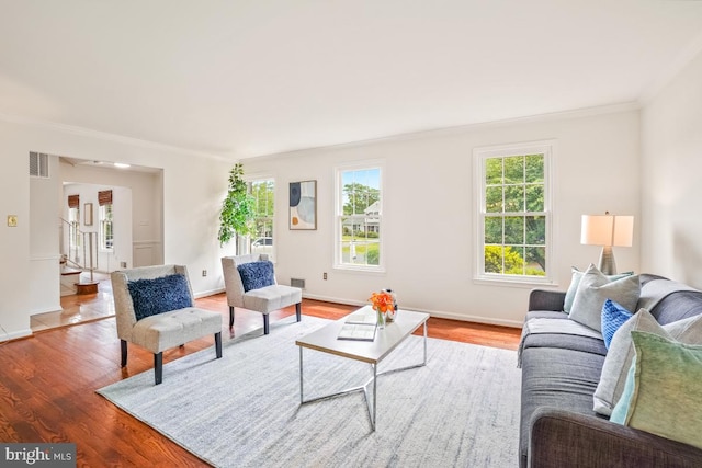 living room featuring crown molding, wood finished floors, and baseboards