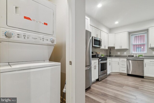 2654 Boone St, Baltimore, MD 21218 - kitchen featuring stainless steel appliances, estacked washer and dryer, a sink, white cabinets, and recessed lighting