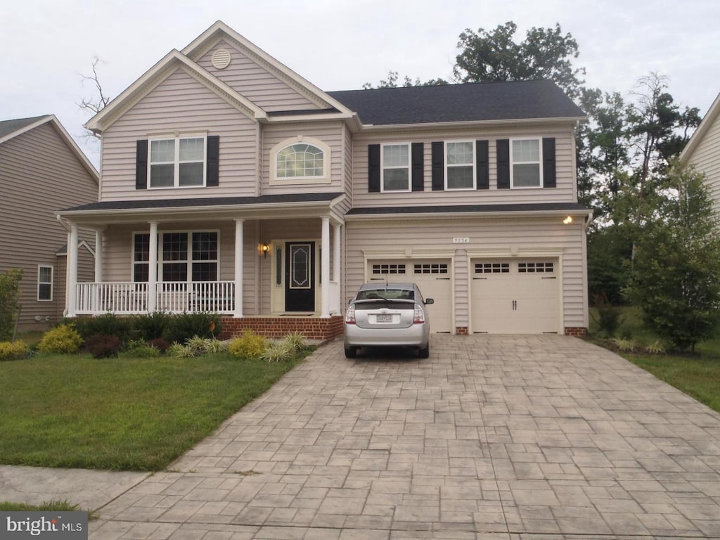 view of front of property featuring a garage, a porch, decorative driveway, and a front lawn