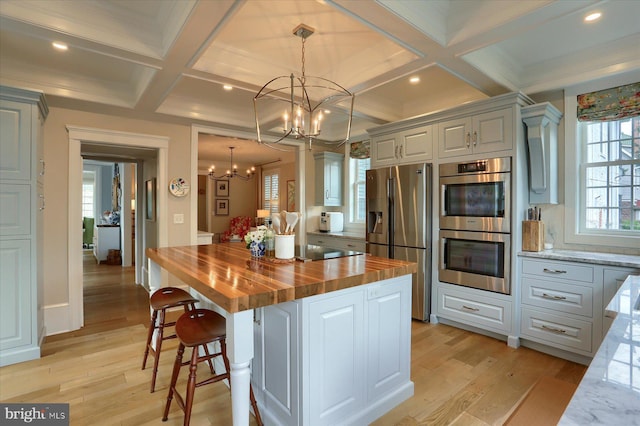 65 S College St, Carlisle, PA 17013 - kitchen with butcher block counters, appliances with stainless steel finishes, coffered ceiling, a chandelier, and a kitchen island