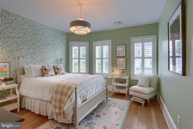 65 S College St, Carlisle, PA 17013 - bedroom with wallpapered walls, hardwood / wood-style flooring, baseboards, and an accent wall