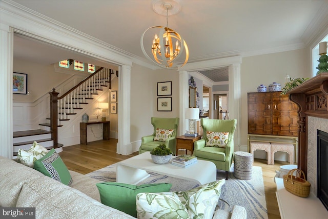 65 S College St, Carlisle, PA 17013 - living area featuring wood finished floors, stairway, a chandelier, ornamental molding, and a fireplace with raised hearth