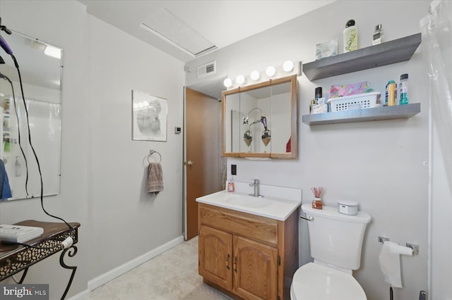 bathroom featuring toilet, vanity, baseboards, and tile patterned flooring