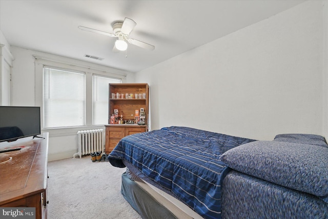 bedroom with radiator, carpet floors, a dry bar, and a ceiling fan