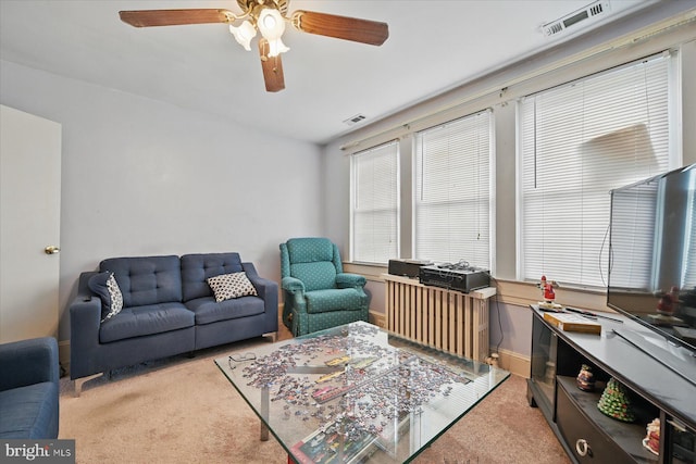 living area featuring carpet and a ceiling fan