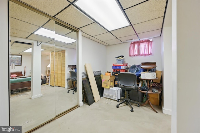 home office featuring a paneled ceiling and concrete floors