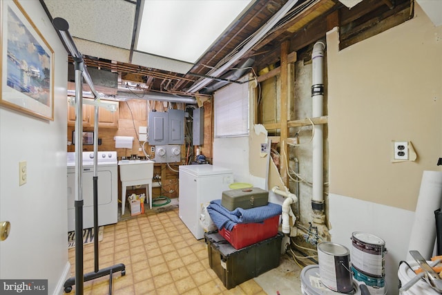 unfinished basement featuring washing machine and dryer, tile patterned floors, and electric panel