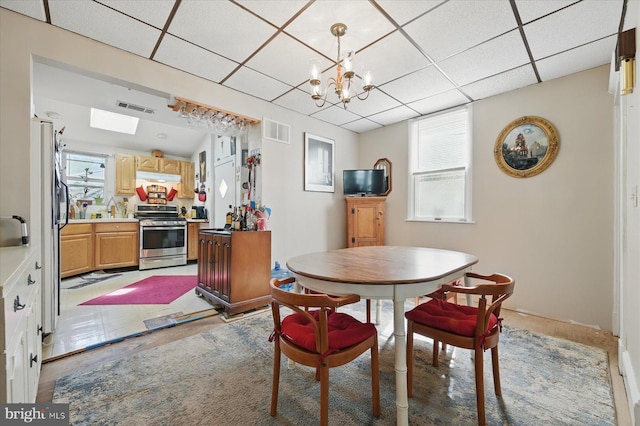 dining area featuring a drop ceiling and a chandelier
