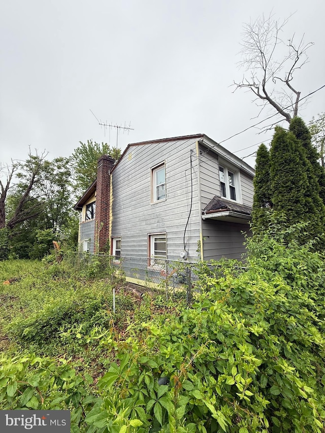 1905 Bellevue Ave, Deptford, NJ 08096 - view of side of home featuring fence and a chimney
