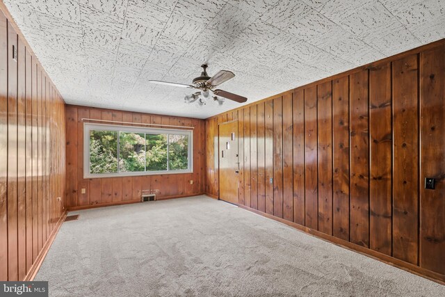 10699 Harding Rd, Laurel, MD 20723 - empty room with carpet flooring, a ceiling fan, wooden walls, and baseboards