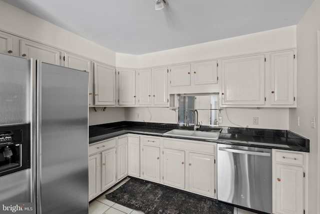 10699 Harding Rd, Laurel, MD 20723 - kitchen featuring appliances with stainless steel finishes, a sink, dark countertops, and white cabinetry