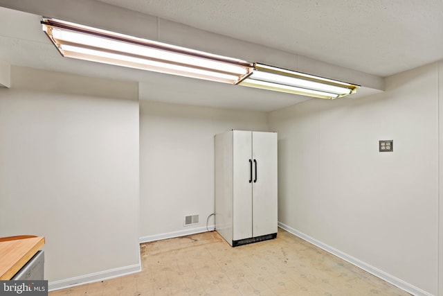 10699 Harding Rd, Laurel, MD 20723 - basement with light floors, baseboards, and freestanding refrigerator