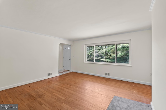 10699 Harding Rd, Laurel, MD 20723 - empty room featuring arched walkways, wood-type flooring, and baseboards