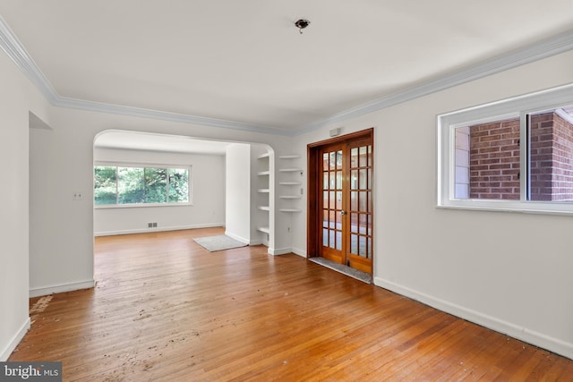 10699 Harding Rd, Laurel, MD 20723 - unfurnished room featuring crown molding, light wood-style floors, arched walkways, baseboards, and french doors
