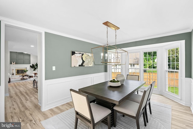 2619 Stone Mountain Ct, Herndon, VA 20170 - dining space with ornamental molding, light wood-style flooring, a chandelier, wainscoting, and a decorative wall