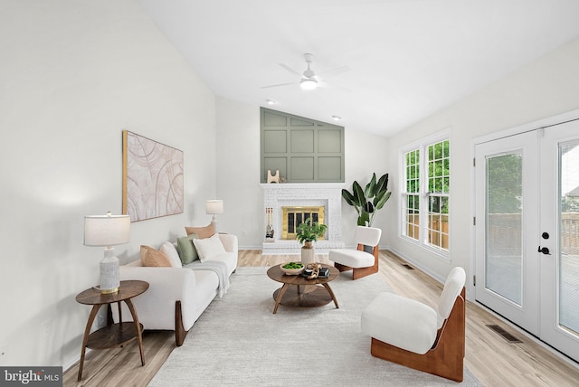 2619 Stone Mountain Ct, Herndon, VA 20170 - living room featuring light wood-style flooring, vaulted ceiling, ceiling fan, a brick fireplace, and baseboards
