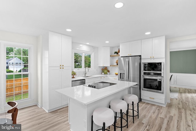 2619 Stone Mountain Ct, Herndon, VA 20170 - kitchen featuring black appliances, open shelves, light wood-style floors, a kitchen island, and white cabinets
