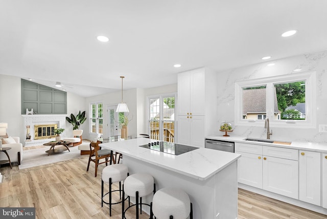 2619 Stone Mountain Ct, Herndon, VA 20170 - kitchen with a sink, black electric stovetop, dishwasher, light wood-type flooring, and a kitchen breakfast bar