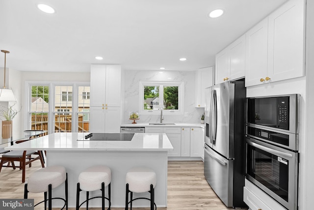 2619 Stone Mountain Ct, Herndon, VA 20170 - kitchen with stainless steel appliances, a kitchen bar, a sink, plenty of natural light, and recessed lighting