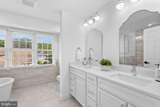2619 Stone Mountain Ct, Herndon, VA 20170 - full bathroom featuring double vanity, tile walls, toilet, a shower with shower door, and a soaking tub