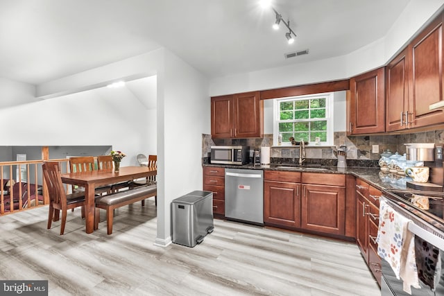 8328 Ridge View Rd, Lusby, MD 20657 - kitchen featuring stainless steel appliances, a sink, light wood-type flooring, decorative backsplash, and dark stone countertops