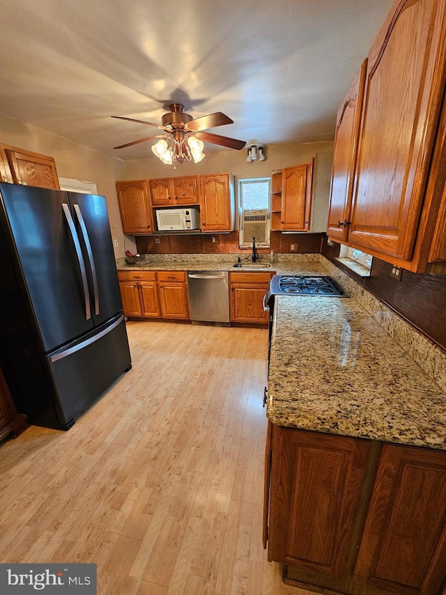 3 W Elm Ave, Baltimore, MD 21206 - kitchen featuring freestanding refrigerator, dishwasher, brown cabinetry, white microwave, and light wood finished floors