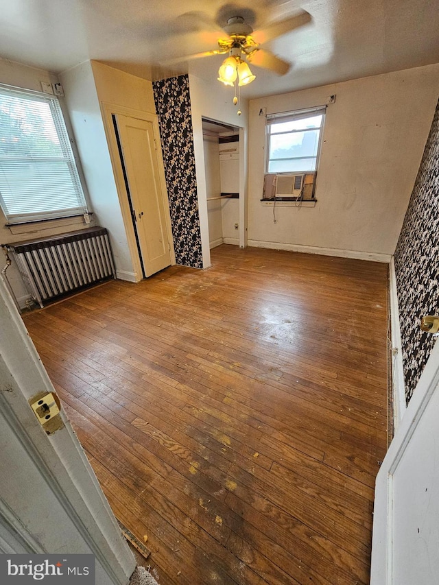 3 W Elm Ave, Baltimore, MD 21206 - unfurnished bedroom with wood-type flooring, multiple closets, a ceiling fan, and radiator heating unit