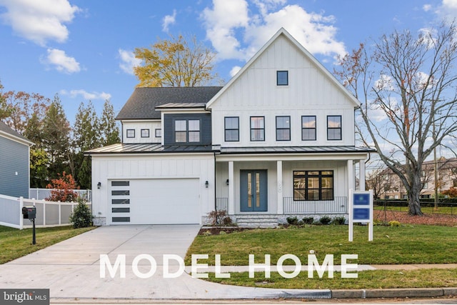 modern inspired farmhouse featuring a standing seam roof, covered porch, board and batten siding, and driveway