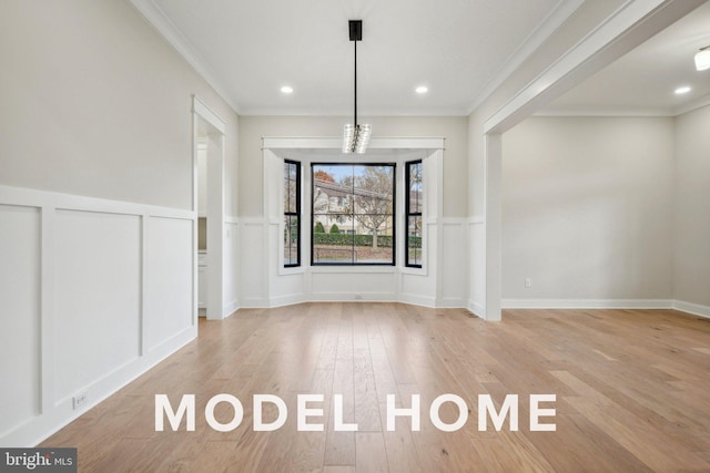unfurnished dining area with light wood-type flooring, crown molding, a wainscoted wall, a decorative wall, and recessed lighting