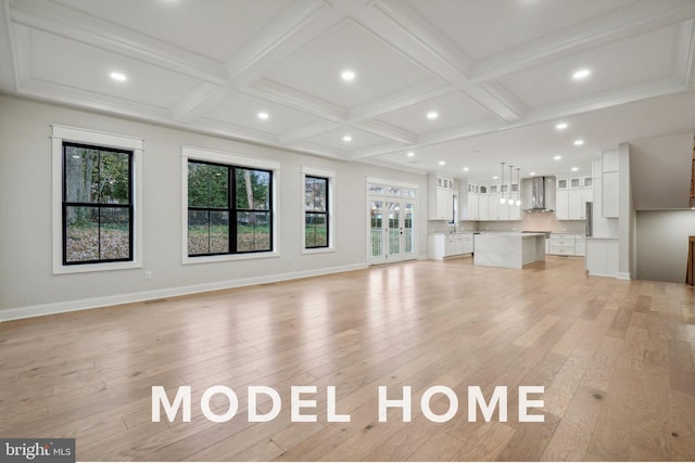 unfurnished living room featuring light wood finished floors, coffered ceiling, recessed lighting, baseboards, and beamed ceiling