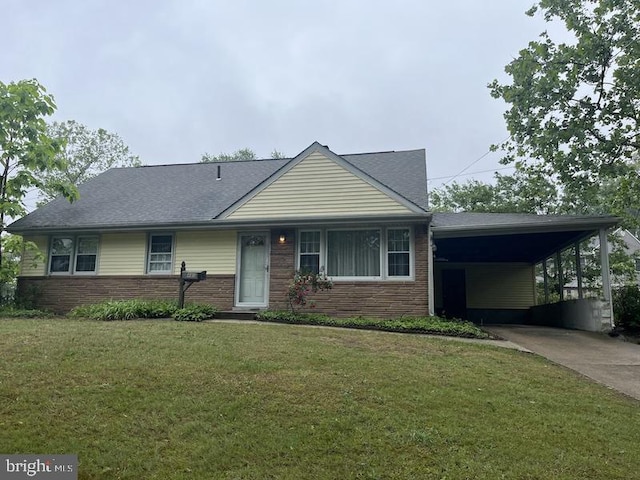 view of front of house featuring concrete driveway, brick siding, a front yard, and an attached carport