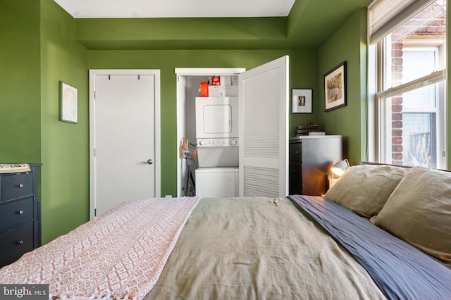bedroom with stacked washer / drying machine