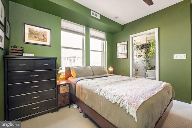 bedroom featuring light carpet and ensuite bath