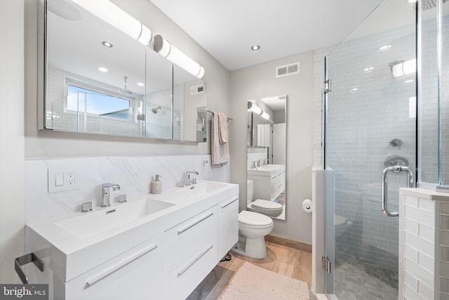 721 S Smedley St, Philadelphia, PA 19146 - bathroom with wood finished floors, a stall shower, double vanity, toilet, and recessed lighting