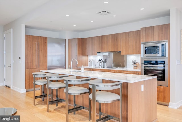 50 S 16th St Unit 5401, Philadelphia, PA 19102 - kitchen featuring appliances with stainless steel finishes, a sink, brown cabinets, modern cabinets, and recessed lighting