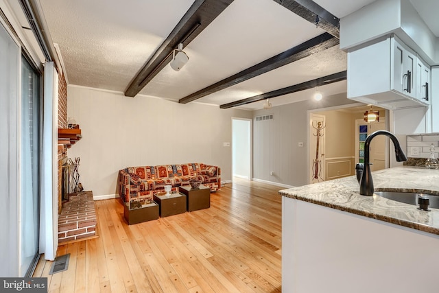 1012 Valewood Rd, Towson, MD 21286 - living area featuring beam ceiling, light wood-type flooring, baseboards, and a fireplace