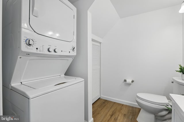 9928 Brookridge Ct, Gaithersburg, MD 20886 - washroom with estacked washer and dryer, light wood-style floors, and baseboards