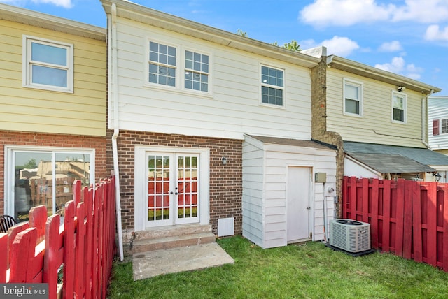 rear view of house featuring central air condition unit and brick siding