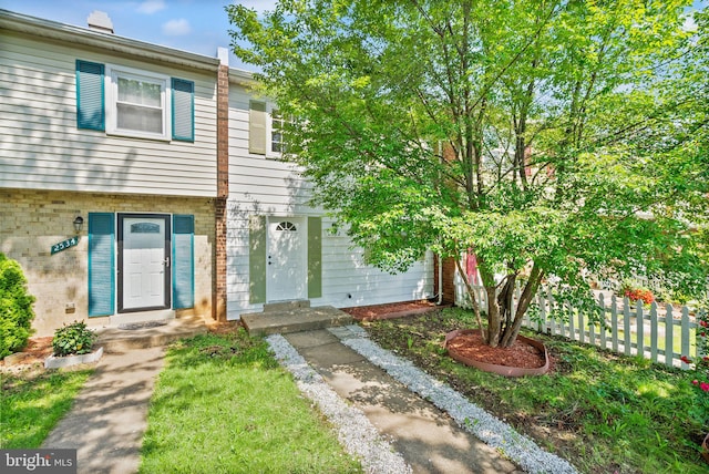 townhome / multi-family property featuring fence and brick siding