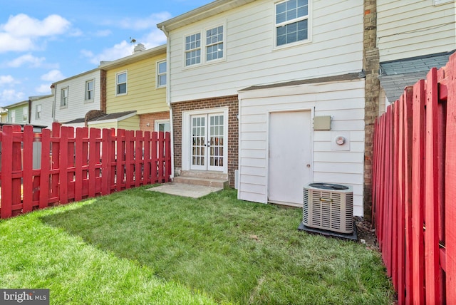 rear view of property featuring brick siding, cooling unit, french doors, and entry steps