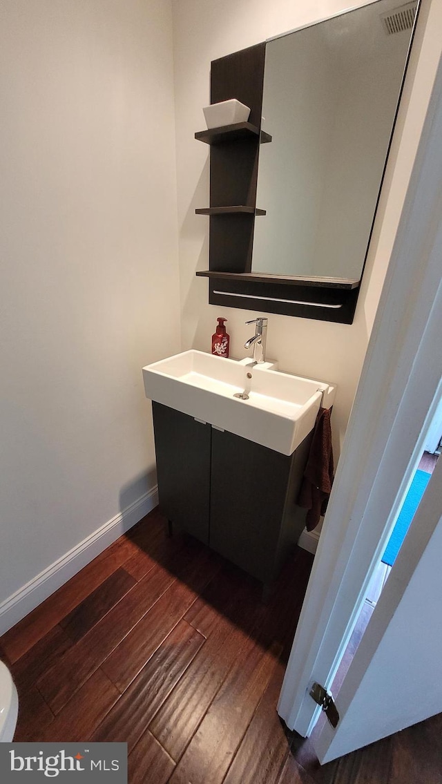 bathroom featuring wood finished floors, vanity, and baseboards